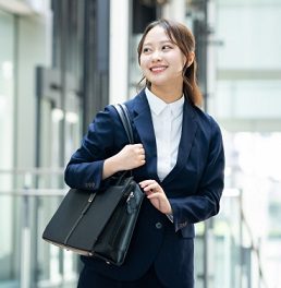 就職活動でバッグを持つスーツ姿の女性のイメージ