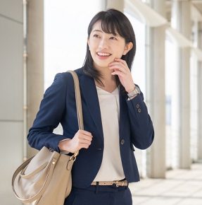 ベージュのトートバッグを持ったスーツ姿の女性のイメージ