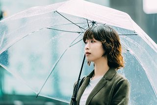 雨の日に傘を使って通勤する女性のイメージ
