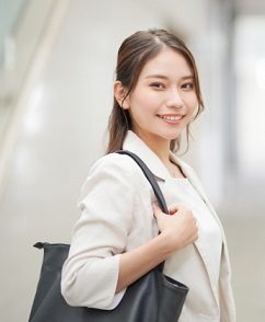 通勤バッグを肩に掛けて歩く女性