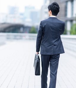 就活バッグを持って移動するスーツ姿の男性