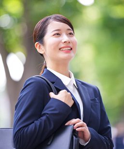 ネイビートートバッグを肩に掛けて歩く就活中の女性